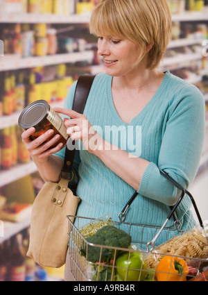Woman reading food label in grocery store Stock Photo