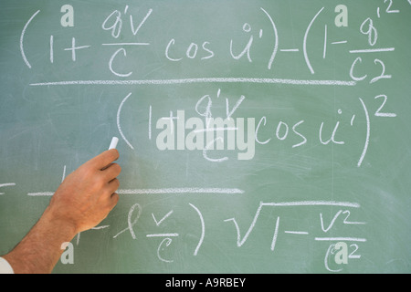 Professor writing formulae on blackboard Stock Photo