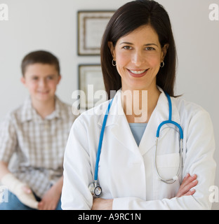 Female doctor with boy in background Stock Photo