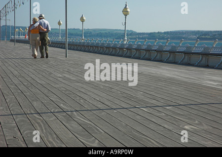 A happy loving older couple walking together on a seaside pier. Stock Photo