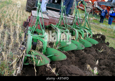 Horizontal Antique tractor pulling a five furrow plough Stock Photo - Alamy