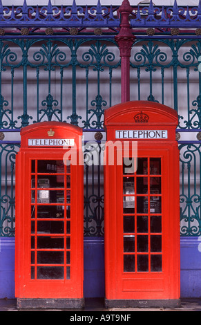 Pair of classic red British public telephone boxes standing on Grand Avenue under arches of Smithfield Market, City of London Stock Photo