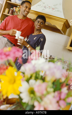 Young afro American couple in kitchen talking over breakfast coffee morning Stock Photo