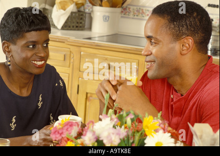 Young afro American couple in kitchen talking over breakfast coffee morning Stock Photo