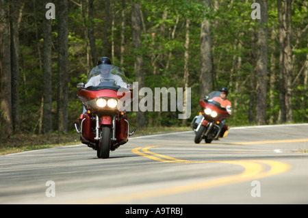 Two motorcycles being ridden on a twisting rural road Stock Photo