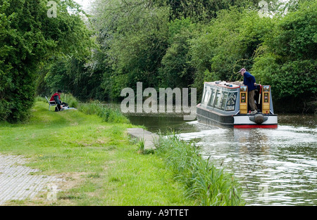 canal barge boating on the grand union with man fishing