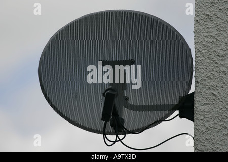 Satellite dish attached to side of house Stock Photo