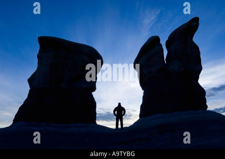 Man standing between two sandstone features in Devil's Garden Utah