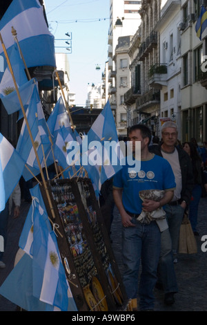 Local men walking past a stall selling Argentinian flags Stock Photo