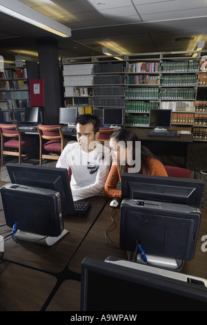 Two university students using computers in the library Stock Photo