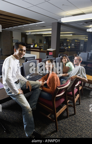Portrait of students sitting together while using computers in the library Stock Photo