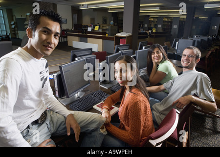 Portrait of students sitting together while using computers in the library Stock Photo
