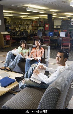Students in library sitting on sofas studying Stock Photo