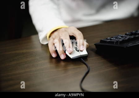 Close-up of a human hand using computer mouse Stock Photo
