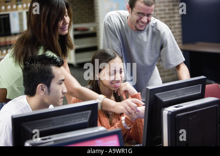 Young students pointing towards a computer monitor Stock Photo