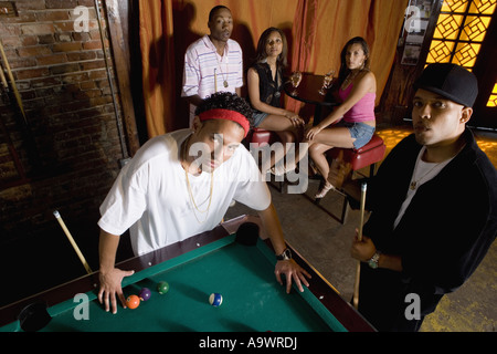 Portrait of young men in hip-hop fashion leaning against pool table Stock Photo