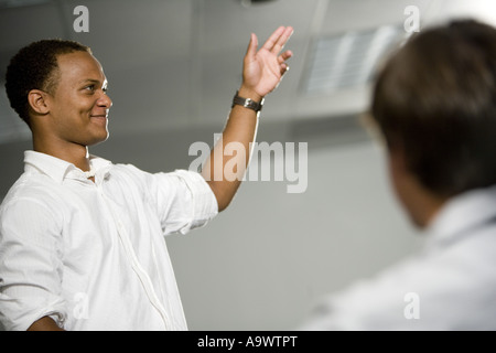 Teacher standing in the classroom gesturing towards class Stock Photo