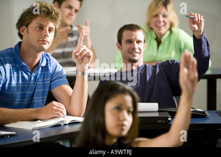 Students raising hands in the classroom Stock Photo