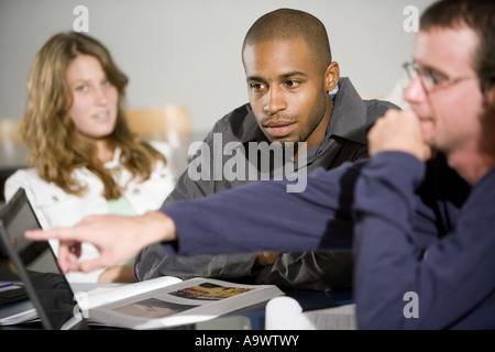 Students studying and using laptop computer in the classroom Stock Photo