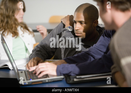 Students studying and using laptop computer in the classroom Stock Photo