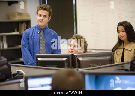 Young office workers gathered around computer screen Stock Photo