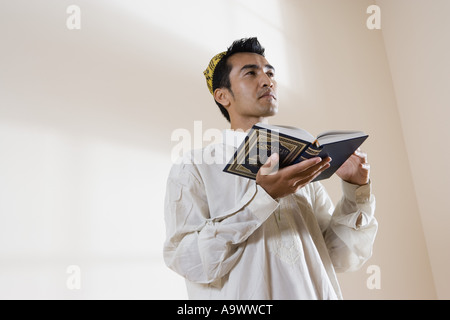 A Muslim man holding Koran Stock Photo