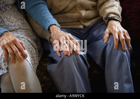 Close-up of senior couple holding hands while sitting Stock Photo