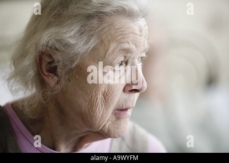Close-up of a stoic and pensive senior woman staring into space Stock Photo