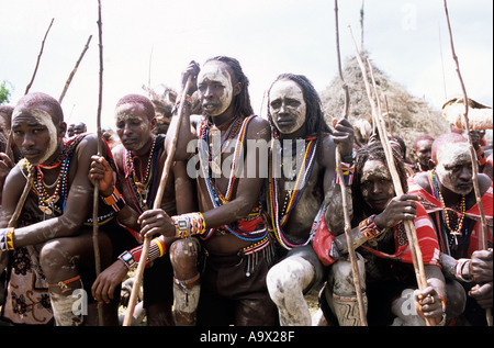 Lolgorian, Kenya. Siria Maasai; Eunoto ceremony; line of kneeling moran with white ochre body paint. Stock Photo