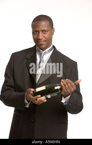 Attractive young man in formal wedding clothes holding a bottle of wine Stock Photo