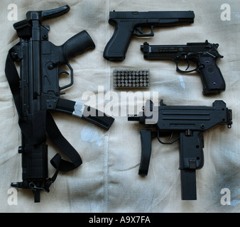 a selection of handguns including an uzi sub machinegun an heckler and koch MP5 machinegun beretta and glock 17L pistols Stock Photo