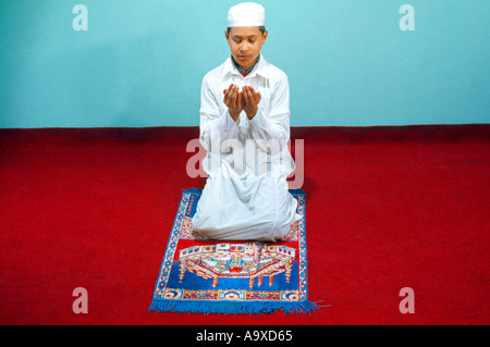 Islam Muslim Saudi Arabia Boy Praying Prayer mat Stock Photo