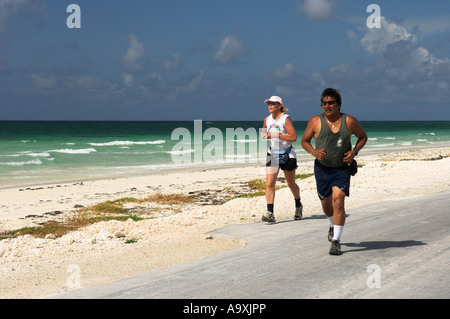 Runners exercising on beach road Stock Photo