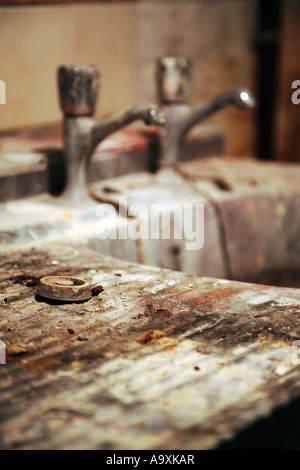 Old, dirty an rusty sink with two faucets and a plug. Stock Photo