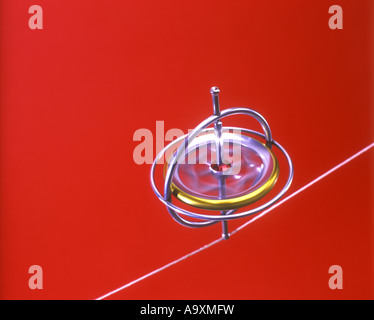 SPINNING GYROSCOPE BALANCES SUSPENDED ON STRING BLUE BACKGROUND Stock ...