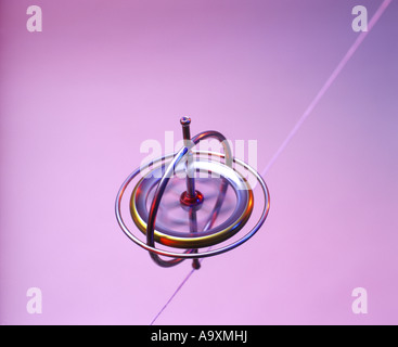 SPINNING GYROSCOPE BALANCES SUSPENDED ON STRING RED BACKGROUND Stock ...