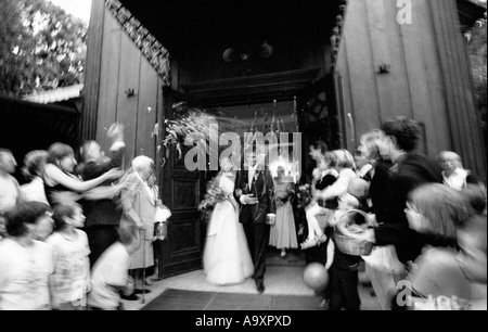 Poland, Lodz, guests throwing rice at bride and groom (B&W) Stock Photo