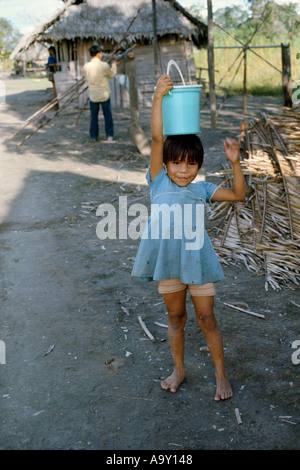 Shipibo Indian girl carrying water in village on shores of Ucayali River Peru Shipibo language belongs to the Panoan family Stock Photo