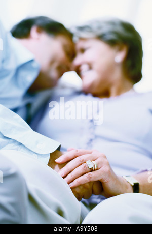 middle aged couple embracing on sofa Stock Photo