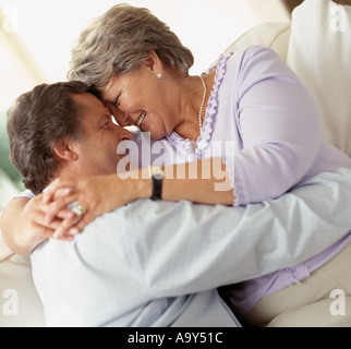 middle aged couple hugging on sofa Stock Photo