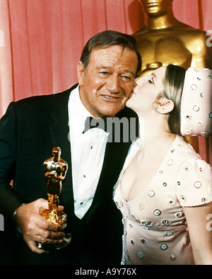 JOHN WAYNE is congratulated by Barbra Streisand after receiving his Oscar for TRUE GRIT in 1969 Stock Photo