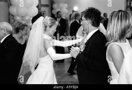 Poland, Lodz, bride with groom and wedding guests dancing in party (B&W) Stock Photo