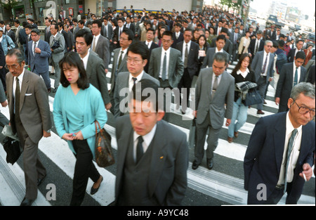 Commuters cross a zebra crossing in Tokyo during the morning rush hour Stock Photo