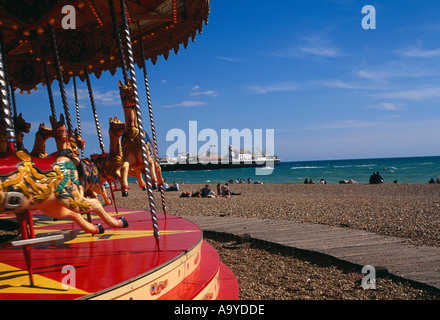 The carousel or Gallopers in the foreground with the Palace Pier (now called Brighton Pier) in the background Stock Photo