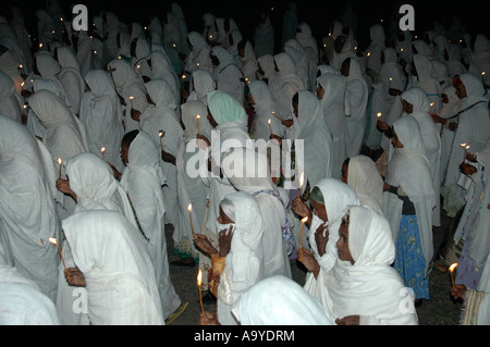 Procession at nighttime of ethiopiean orthodox believers in white capes with candles Aksum Ethiopia Stock Photo