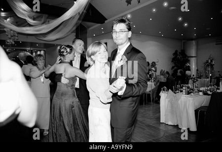 Poland, Lodz, groom and wedding guests dancing at party, portrait (B&W) Stock Photo