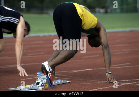 Runner in set position before 100m race on an athletics track, UK Stock Photo