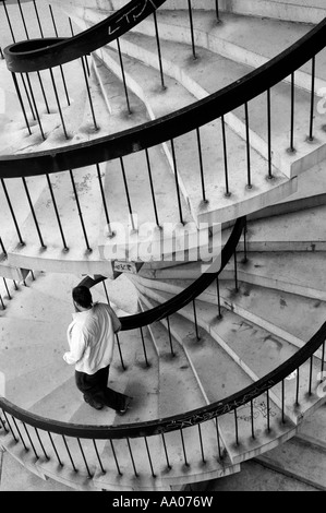 Man on spiral stairway Stock Photo
