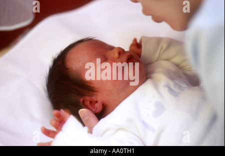 mother bending over new-born baby with arm reaching out Stock Photo - Alamy