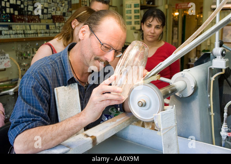 engraver at his wheel with three people watching, in Lutzelbourg Alsace France Stock Photo